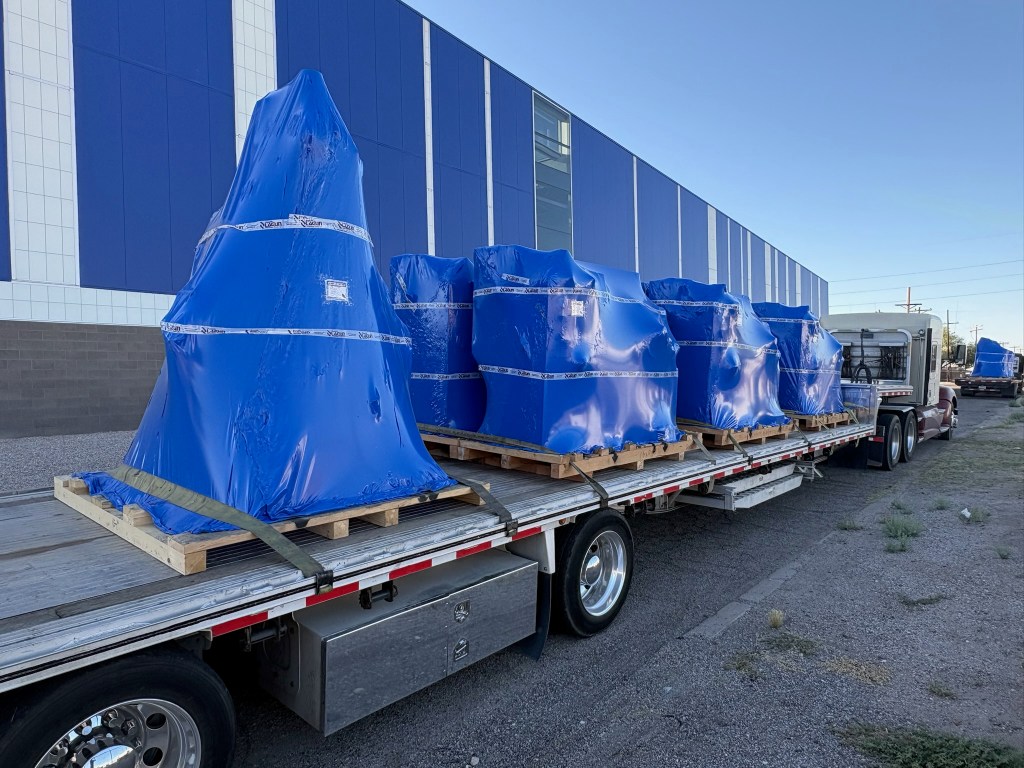 Blue wrapped Lagun machines secured on a flatbed truck for delivery to Pima Community College’s machining program.